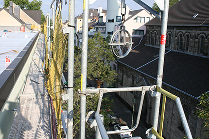 Blick auf ein Gerüst am Jugendhaus Düsseldorf. Im Hintergrund sind Gebäude und Bäume sichtbar.