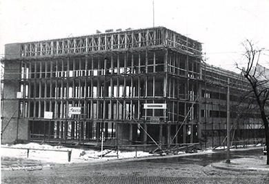 Ein historisches Foto zeigt den Rohbau eines Gebäudes auf einer verschneiten Baustelle, das zukünftige Jugendhaus Düsseldorf.
