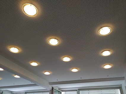 Decke des Konferenzraums im Jugendhaus Düsseldorf mit neun runden, eingelassenen Deckenlampen, die gleichmäßig verteilt sind.